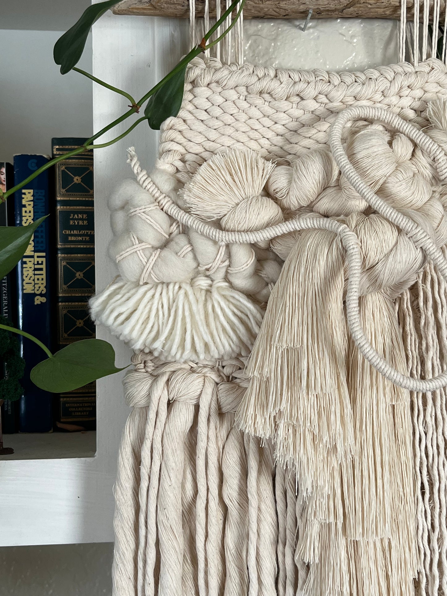 close up of a textured woven wall hanging made in a neutral color palette
