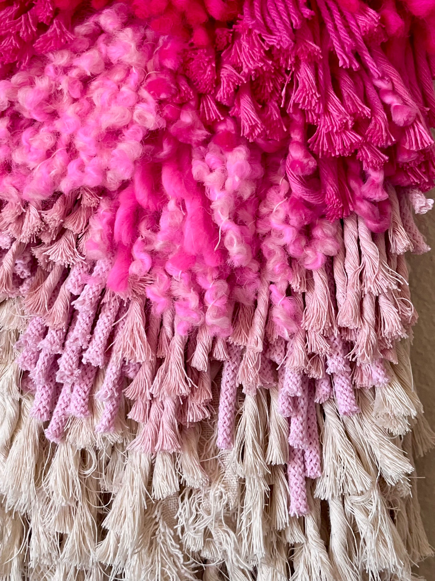 Close-up of a textured pink and white wall hanging